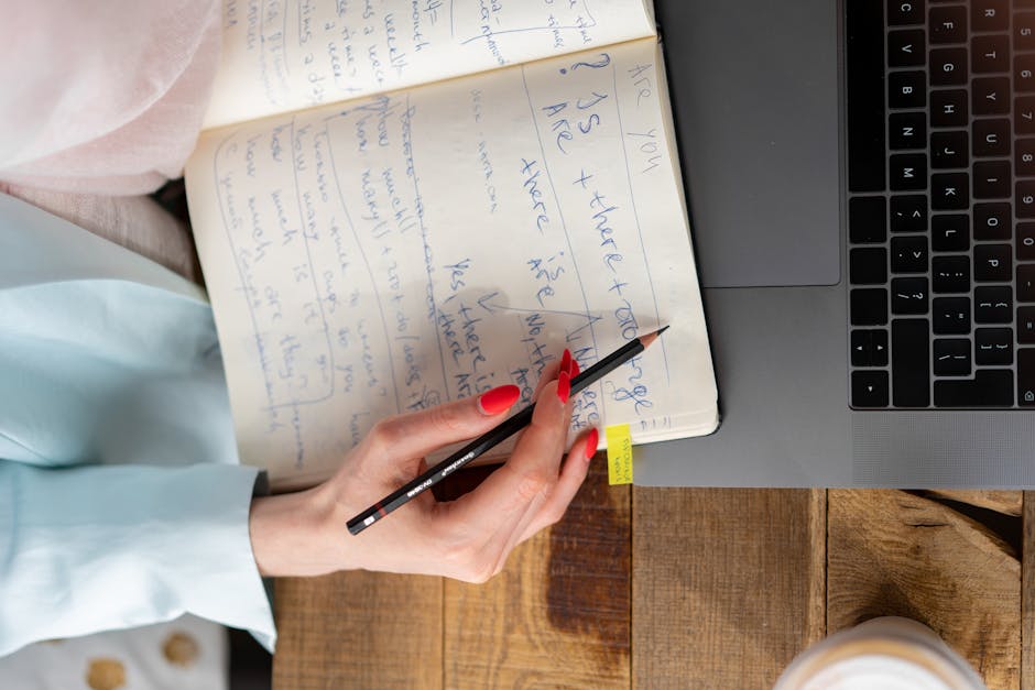 A person smiling while writing down goals in a planner at a sunlit desk.